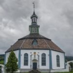 a church with a steeple on a cloudy day