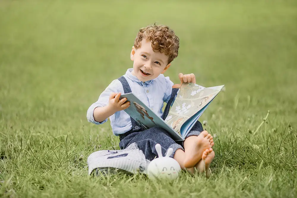 enfant qui regarde un livre dans un parc