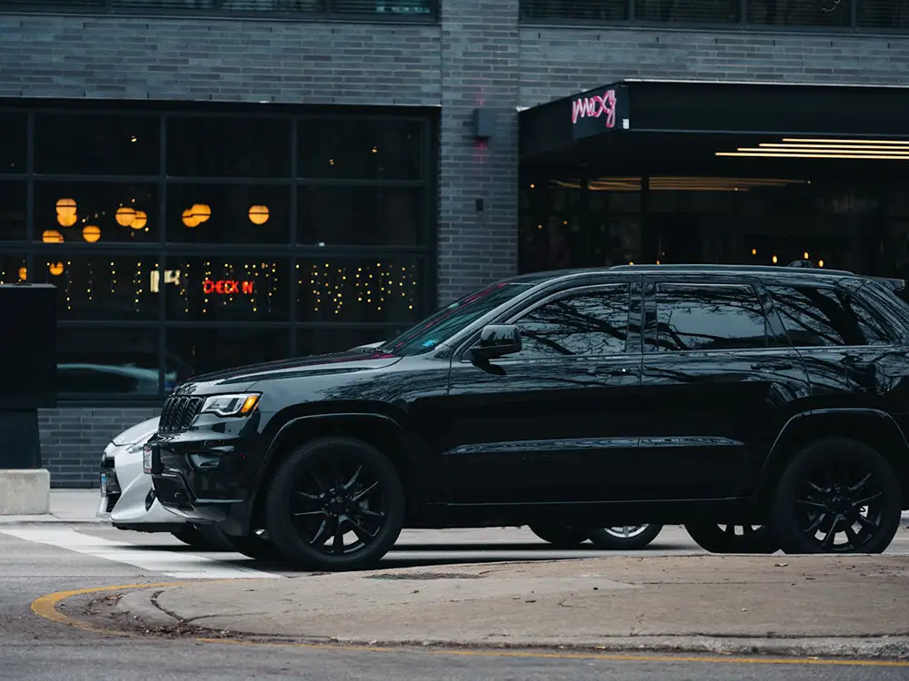 SUV noir dans un parking devant un restaurant