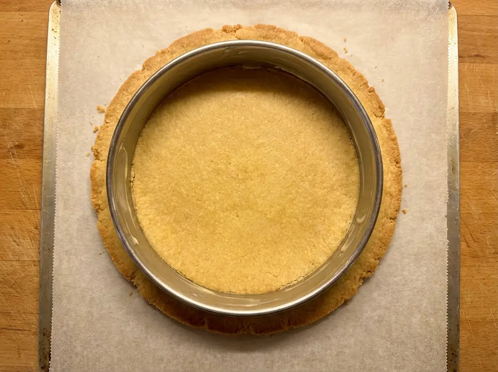 Disque de pâte doré sur plaque avec cercle inox de 18 cm posé dessus