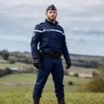 Réserviste de la Gendarmerie nationale en uniforme bleu avec ceinturon, holster et gants tactiques lors d'une patrouille