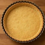 Fond de tarte en pâte brisée maison rétréci après cuisson dans un moule